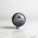 Natural agate crystal sphere with striking banded layers in grey and earth tones, 433g, for grounding, balance and stability