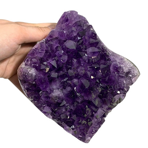 Kindred Crystal Collective — Amethyst Cluster, hand-held natural Amethyst druzy cluster showing deep purple crystal formation and dark matrix base, size reference