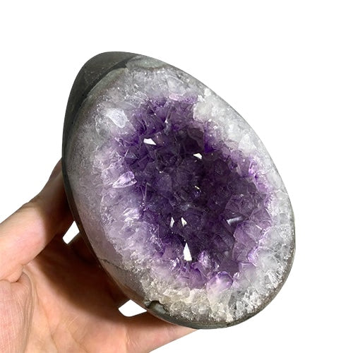 Kindred Crystal Collective — Amethyst Druzy Egg, hand-held polished Amethyst druzy egg showing mixed lavender and deep violet crystal cavity with clear quartz druzy surround, size reference