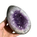 Kindred Crystal Collective — Amethyst Druzy Egg, hand-held polished Amethyst druzy egg showing mixed lavender and deep violet crystal cavity with clear quartz druzy surround, size reference