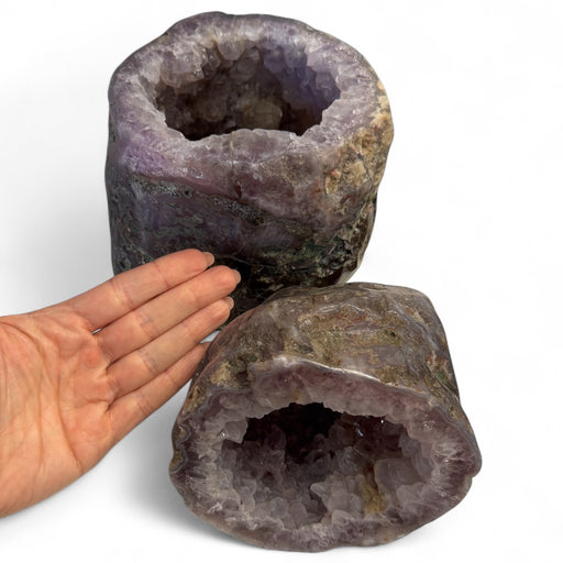 Kindred Crystal Collective — Amethyst Geode Pair, front view of natural amethyst geode pair showing mirrored violet crystal formations and natural outer shell