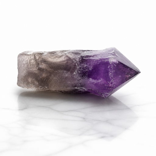 Kindred Crystal Collective — Amethyst Point, natural raw amethyst crystal point with smoky grey base graduating to deep violet tip, displayed on white marble surface
