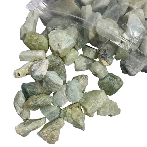 Kindred Crystal Collective — Aquamarine Rough 1KG, soft blue raw aquamarine chunks spilling from a clear bag on white background.

