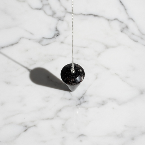 Astrophyllite crystal pendulum showing shimmering star-burst inclusions, a rare healing crystal for emotional light work