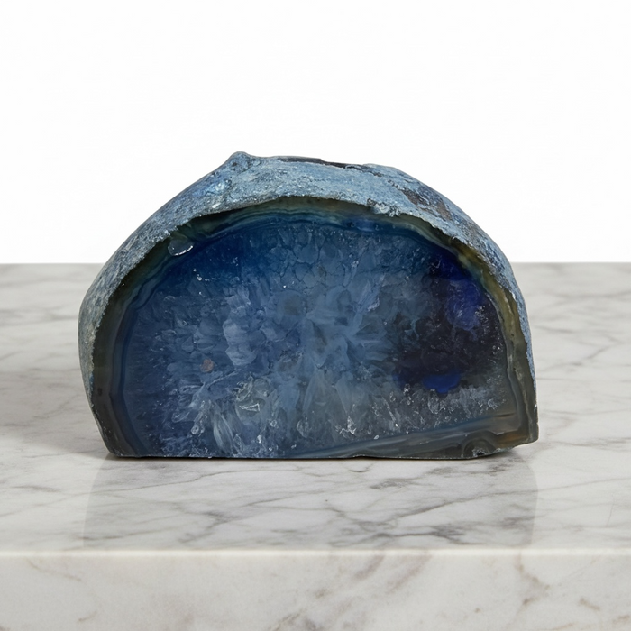 Kindred Crystal Collective - Blue Agate tealight holder carved from a natural geode half, showing deep teal and midnight blue banding with a smooth polished interior.