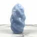 Kindred Crystal Collective - A polished light blue calcite flame with organic, flowing contours, standing on a white marble surface against a white background.