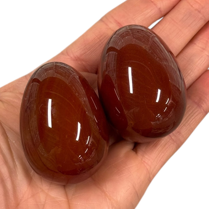 Kindred Crystal Collective — Carnelian Egg, two polished deep reddish-brown crystal eggs 