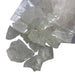  Kindred Crystal Collective — Clear Quartz Rough 1kg, clear-to-cloudy unpolished quartz pieces spilling from a clear bag onto a white background.