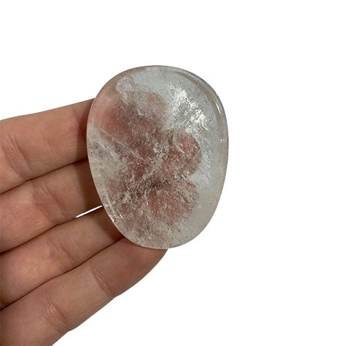 Kindred Crystal Collective — Clear Quartz Worry Stone, polished oval clear quartz with visible internal inclusions held between fingers.