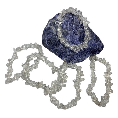 Kindred Crystal Collective — Clear Quartz Chip Bracelets (Pack of 5), five clear-to-cloudy crystal chip bracelets arranged around a dark blue display stone.