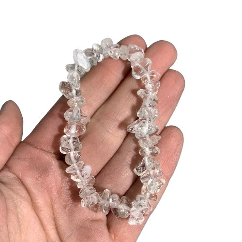 Kindred Crystal Collective — Clear Quartz Chip Bracelets (Pack of 5), five clear-to-cloudy crystal chip bracelets arranged around a dark blue display stone.
