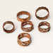 Kindred Crystal Collective - Six copper-toned metal rings with textured, hammered, and twisted finishes arranged on a light beige background.