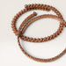 Kindred Crystal Collective — Cubit Tensor Bracelets, two handcrafted pure copper open-cuff bracelets overlapping on white background showing Cubit Tensor style (twisted wire with ball-end tips) and Hammered style (flat woven copper scale band)