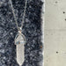 Crystal pendant necklace on a dark stone surface
