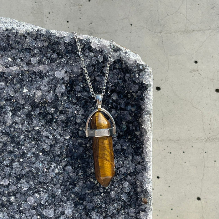 Tiger's eye pendant necklace on a stone surface