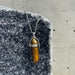 Tiger's eye pendant necklace on a stone surface
