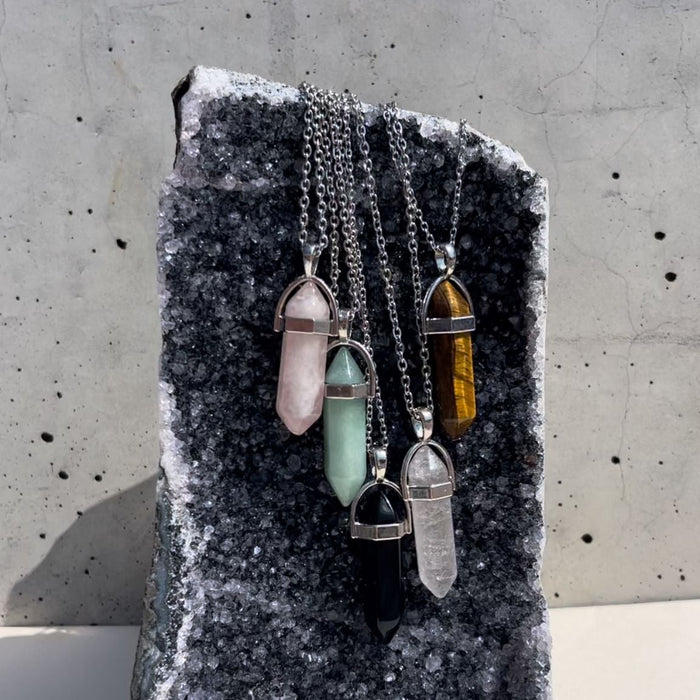 Crystal necklaces on a stone surface with a concrete background