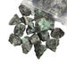 Kindred Crystal Collective — Emerald Rough 1KG, rich green raw emerald chunks spilling from a clear bag on white background.