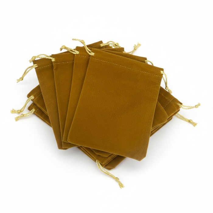 Stack of gold velvet drawstring bags on a white background