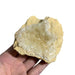 Kindred Crystal Collective — Golden Calcite Cluster, hand-held natural Golden Calcite cluster showing amber-yellow host rock matrix and granular cream-white druzy crystal formation, size reference