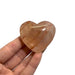 Kindred Crystal Collective — Hematoid Quartz Heart, hand-held polished Fire Quartz crystal heart showing warm peach tones and natural Hematite banding, size reference