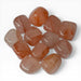 Kindred Crystal Collective — Hematoid Quartz Tumbled Stones, pile of polished Fire Quartz tumbles showing warm peach to rust-orange colouring with natural Hematite streaking and semi-translucent Quartz body, white background