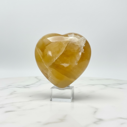 Natural honey calcite carved crystal heart in warm golden amber, 173g, for confidence, clarity and steady direction