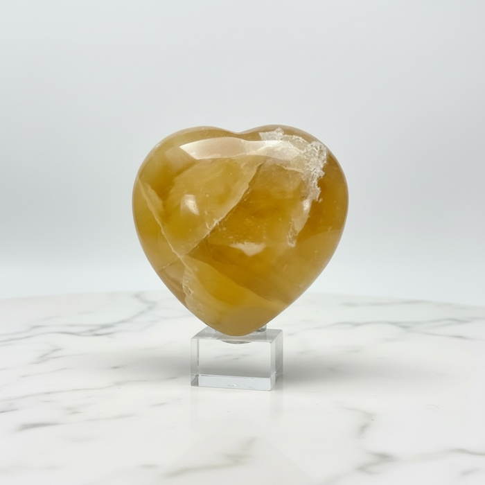 Natural honey calcite carved crystal heart in warm golden amber, 173g, for confidence, clarity and steady direction