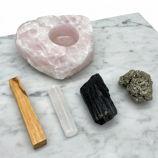 House Cleansing Crystal Bundle flat lay featuring Black Tourmaline, Selenite, Pyrite, Rose Quartz tea-light candle and Palo Santo | Kindred Crystal Collective