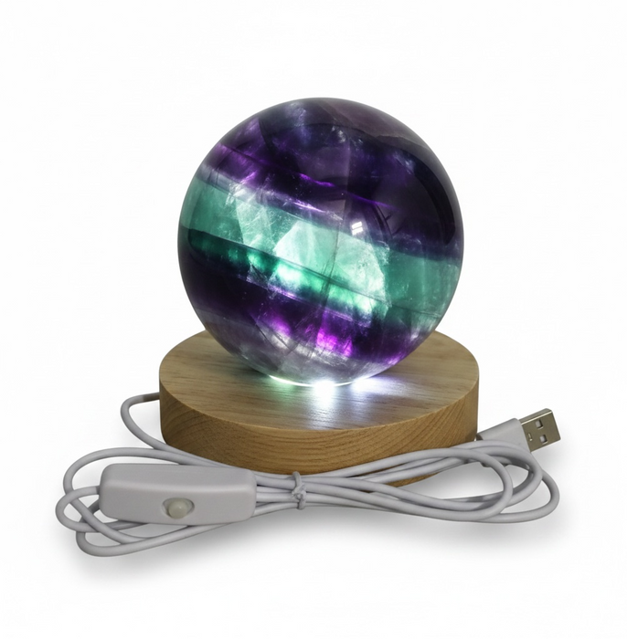 Colorful spherical light on a wooden base with USB cable on a white background