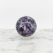 Kindred Crystal Collective — Lepidolite Sphere, polished speckled purple and lavender lepidolite sphere on clear display stand, white background