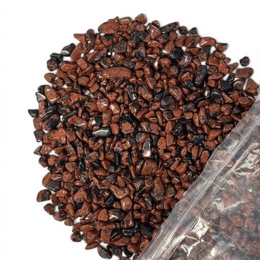 Kindred Crystal Collective — Mahogany Obsidian Chips 500g, tumbled mahogany-brown and black obsidian chips poured from clear bag on white background