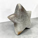 Kindred Crystal Collective — Natural Agate Druzy Star, polished five-point agate star with cream and grey banding surrounding a sparkling druzy cavity, on a light surface.