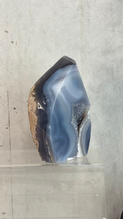 Kindred Crystal Collective — Natural Agate Flame, side view showing translucent grey and ivory banding on polished agate flame