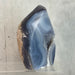 Kindred Crystal Collective — Natural Agate Flame, side view showing translucent grey and ivory banding on polished agate flame
