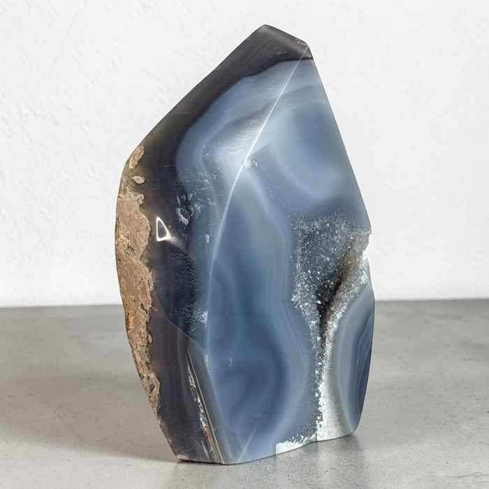 Kindred Crystal Collective — Natural Agate Flame, polished flame-shaped agate with warm honey, rust, grey, and ivory banding, 17x12cm