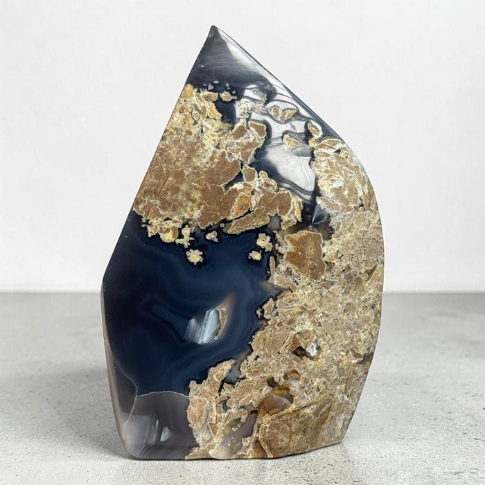 Kindred Crystal Collective — Natural Agate Flame, polished flame-shaped agate with warm honey, rust, grey, and ivory banding, 17x12cm