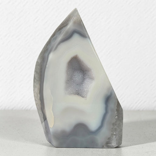 Kindred Crystal Collective — Natural Grey Agate Flame with Druzy Centre, freestanding flame-shaped stone with grey banding and polished and naturally textured surfaces.