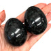 Kindred Crystal Collective - Two polished Nephrite Jade eggs held in an open hand, showing deep dark green colouring with a smooth high-gloss finish.