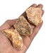 Kindred Crystal Collective — Orchid Calcite Rough 1KG, soft peach and lavender raw calcite chunks spilling from a clear bag on white background.