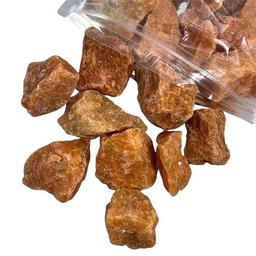 Kindred Crystal Collective — Orchid Calcite Rough 1KG AA+ Grade, soft peach and lavender raw calcite chunks spilling from a clear bag on white background.

