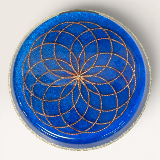 Kindred Crystal Collective — Orgonite Energy Charging Plate, handcrafted cobalt blue resin plate with copper Flower of Life design and silver glitter rim, top view