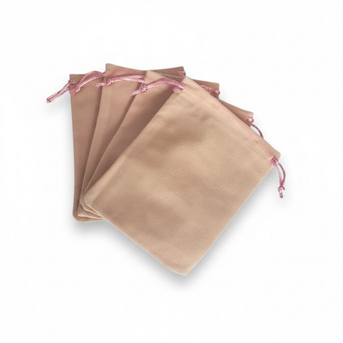 Set of pale pink drawstring bags on a white background