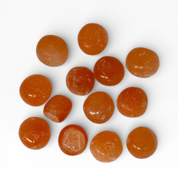 Kindred Crystal Collective — Peach Selenite Tumble Stone, warm apricot-orange disc-shaped selenite tumbles with translucent glow, 200g pack sourced from Morocco
