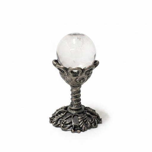Decorative object with a white sphere on an ornate metal stand against a white background
