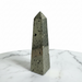 Kindred Crystal Collective — Pyrite Obelisk, polished natural pyrite obelisk with metallic golden-grey cubic crystal surface, white background
