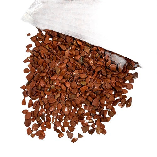 Kindred Crystal Collective — Red Jasper Chips 1KG, small stone chips in warm brick-red and reddish-brown tones spilling from a clear bag.