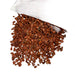 Kindred Crystal Collective — Red Jasper Chips 1KG, small stone chips in warm brick-red and reddish-brown tones spilling from a clear bag.