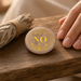 Kindred Crystal Collective — Rose Quartz Yes/No Coin, polished round pink stone with gold-coloured lettering and an ornate scrollwork border.