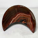 Kindred Crystal Collective — Sardonyx Crescent Moon, polished red-brown and charcoal stone carving with fine white banding.